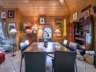 Experience rustic charm in this inviting dining room, featuring a large wooden table perfect for gatherings, surrounded by comfortable seating.