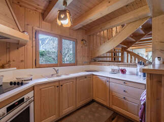 Experience rustic charm in this beautifully appointed wooden kitchen, featuring a double sink, modern stovetop, and oven.