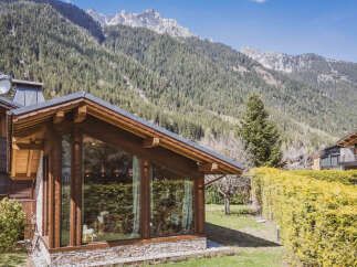 Experience luxury mountain living in this stunning chalet, featuring expansive floor-to-ceiling windows that offer breathtaking views of the surrounding alpine landscape.