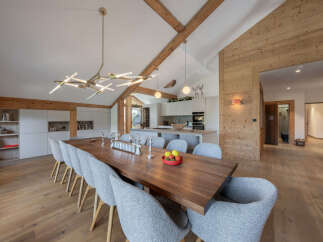 Experience luxurious mountain living in this stunning dining area, featuring a grand wooden dining table perfect for gathering with loved ones.