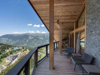 Experience breathtaking mountain vistas from this stunning wooden balcony, perfect for enjoying your morning coffee or evening relaxation.