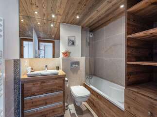 Experience rustic charm in this beautifully appointed bathroom, featuring a wooden vanity with ample storage and a sleek sink.