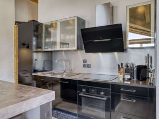 This modern kitchen features sleek black cabinetry and a stainless steel backsplash, creating a sophisticated and functional space.