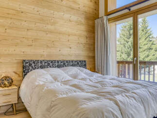 Experience cozy mountain living in this charming bedroom featuring a plush king-sized bed with a decorative headboard.