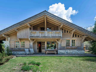 Experience the charm of this rustic wooden chalet, featuring a spacious balcony with intricate detailing and large windows that invite natural light.