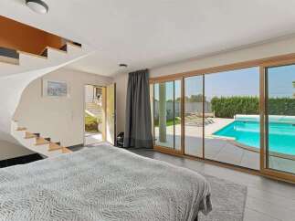 Experience luxurious living with this stunning bedroom featuring direct access to a private swimming pool.