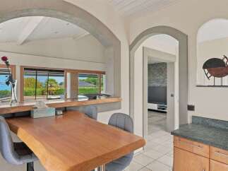 Enjoy breathtaking lake views from this charming dining area, featuring a live-edge wooden table and comfortable seating.