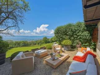 Experience luxurious outdoor living with this stunning patio featuring modern, comfortable seating and a stylish coffee table.