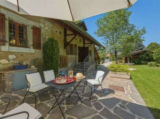 Enjoy outdoor living on this charming patio featuring a table and chairs, perfect for al fresco dining.