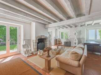 Experience rustic charm in this inviting living room, featuring exposed wooden beams and a stone fireplace.