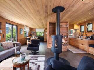 Experience rustic charm in this beautifully appointed wooden chalet, featuring a cozy living area with a modern wood-burning stove and a fully equipped kitchen.