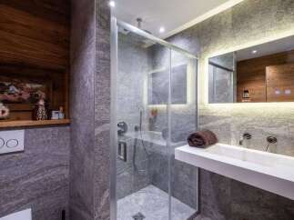 Experience modern luxury in this stunning bathroom, featuring a sleek glass-enclosed shower and a floating vanity with a minimalist sink.
