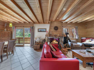Experience rustic charm in this inviting living room, featuring a roaring fireplace and exposed wooden beams.
