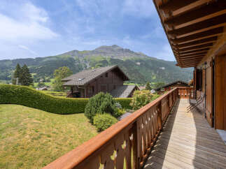 Experience breathtaking mountain views from this charming wooden chalet, featuring a spacious balcony perfect for enjoying the alpine scenery.