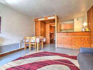 This cozy studio apartment features a dining area with a table and chairs, perfect for meals.