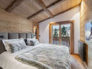 Experience ultimate comfort in this charming mountain bedroom, featuring a plush king-size bed adorned with luxurious faux fur throws and pillows.