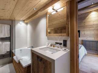 Experience rustic luxury in this charming bathroom featuring a deep soaking tub and a modern vanity with ample counter space.
