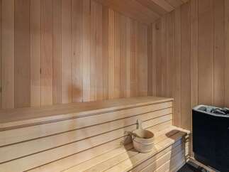Experience ultimate relaxation in this authentic Finnish sauna, featuring natural wood paneling and comfortable tiered benches.