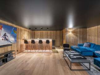Experience ultimate relaxation in this modern entertainment space, featuring a sleek bar area with comfortable stools and a large screen for movie nights.