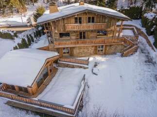 Experience the charm of this stunning wooden chalet nestled in a snowy landscape.