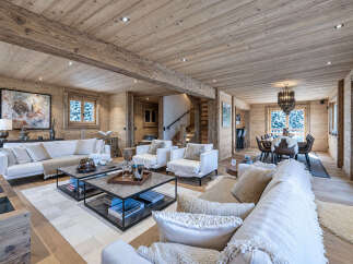 Experience luxurious mountain living in this stunning chalet, featuring a spacious open-plan living area with a modern fireplace and comfortable seating.