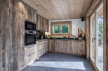 Experience rustic charm in this mountain kitchen, featuring custom wood cabinetry and a sleek built-in oven and microwave.