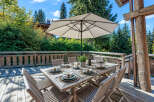 Enjoy al fresco dining on this charming wooden deck, complete with a large table set for six and a spacious umbrella for shade.