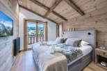 Experience ultimate comfort in this master bedroom, featuring a luxurious king-size bed with plush bedding and a stunning mountain view.