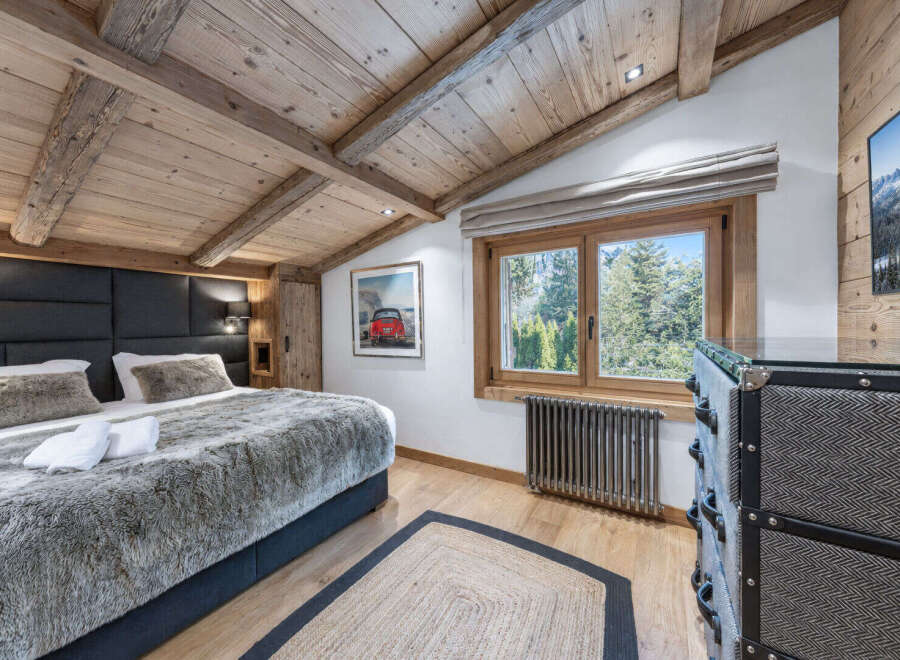 Experience rustic charm in this cozy bedroom, featuring a luxurious faux fur duvet and a stylish upholstered headboard.