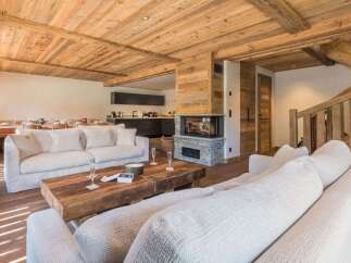 Experience luxury mountain living in this stunning chalet featuring a modern open-plan living area with a cozy fireplace and a fully equipped kitchen.