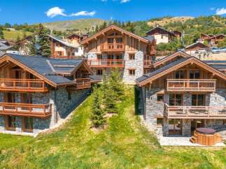 Experience luxury mountain living in this stunning chalet, featuring a modern design with natural wood and stone accents.