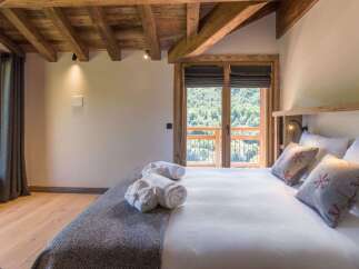 Experience rustic charm and breathtaking mountain views from this cozy bedroom.