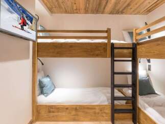Experience cozy mountain living in this charming room featuring rustic wooden bunk beds, perfect for families or groups.