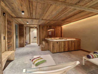 Experience ultimate relaxation in this luxurious spa room, featuring a built-in jacuzzi surrounded by warm, rustic wood paneling.