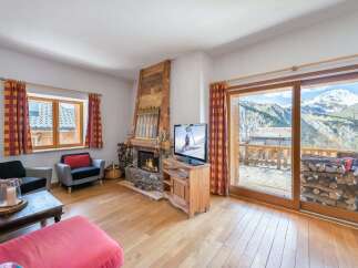 Experience breathtaking mountain views from this charming living room, featuring a cozy fireplace and a large sliding glass door that opens to a scenic balcony.
