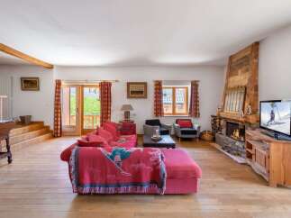 Experience cozy living in this charming living room, featuring a plush pink sectional sofa adorned with a decorative throw.