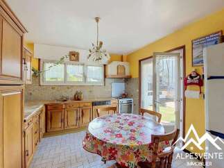 Charming kitchen featuring warm wooden cabinetry and a cozy dining area perfect for family meals.