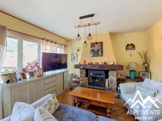 Cozy living room featuring a rustic stone fireplace with a wooden mantel, perfect for gathering on chilly evenings.
