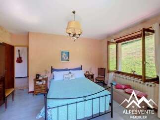 Discover this charming bedroom featuring a comfortable bed with blue bedding and decorative pillows.