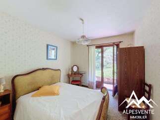 This charming bedroom features a comfortable bed with a yellow accent pillow, perfect for relaxation.