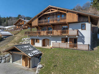 Experience luxury mountain living in this stunning chalet, featuring a multi-level design with expansive wooden balconies offering breathtaking views.