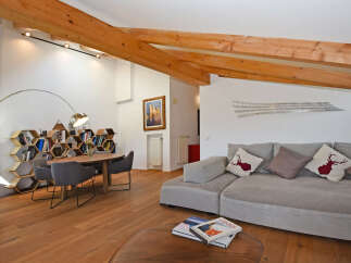 Experience modern alpine living in this stunning property featuring exposed wooden beams and a unique honeycomb bookshelf.