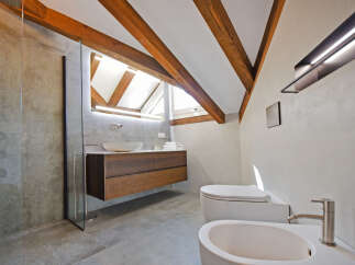 Experience modern luxury in this stunning bathroom featuring a floating wood vanity with a vessel sink and a sleek glass shower enclosure.