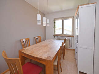This dining room features a large wooden table with four chairs, perfect for family meals and gatherings.