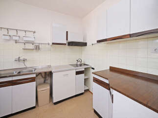 This charming kitchen features ample white cabinetry with elegant wood accents, providing a clean and modern aesthetic.