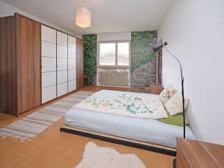 This bedroom features a large wooden wardrobe with white doors, offering ample storage.