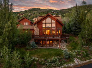 Experience luxury mountain living in this stunning timber-frame home, nestled amidst a serene forest setting.