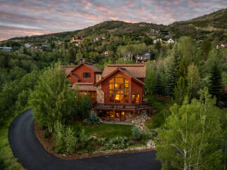 Experience luxury mountain living in this stunning timber-frame home nestled amidst lush greenery and rolling hills.