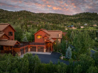 Nestled amidst a lush forest, this stunning mountain home offers breathtaking views and serene privacy.
