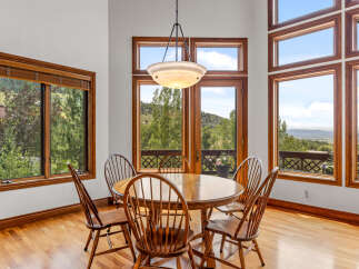 Enjoy breathtaking mountain views from this elegant dining room, featuring a round wooden table with six chairs perfect for intimate gatherings.